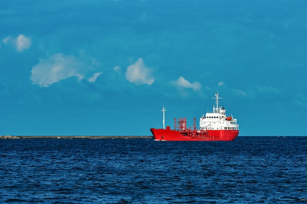 Buque cisterna de carga roja moviéndose por el río