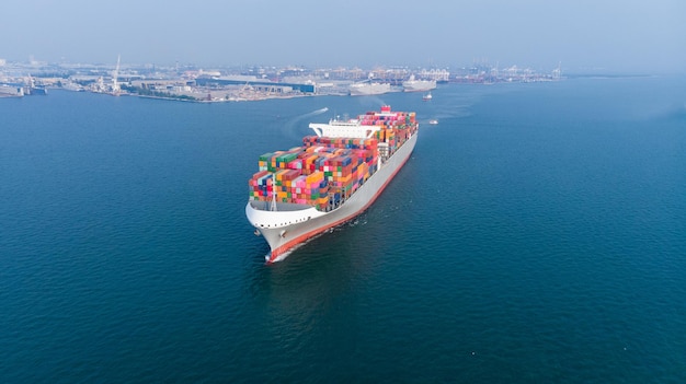Buque de contenedores de carga que se ejecuta cerca de la terminal internacional de carga yarda puerto importación exportación distribuidor servicio logístico y concepto de transporte
