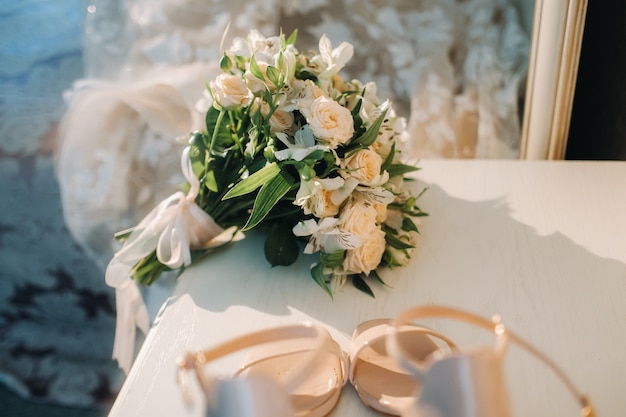 Buquê de casamento com rosas na mesa. A decoração do casamento