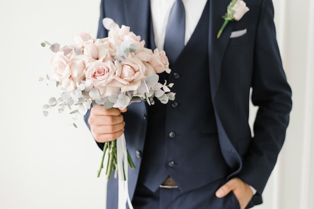 Buquê de casamento elegante de delicadas rosas nas mãos do noivo closeup