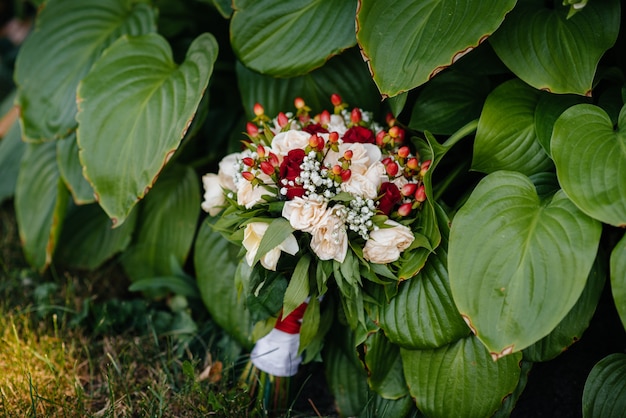 Buquê de casamento lindo na grama verde em um dia de verão.