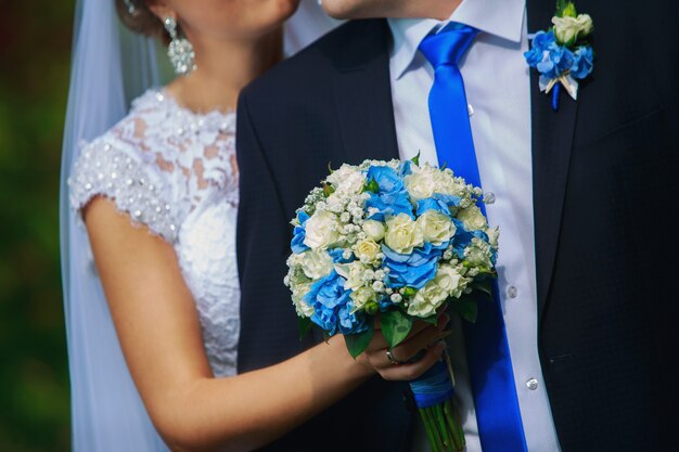 Foto buquê de casamento nas mãos da noiva close-up. conceito de casamento. feliz dia do casamento em estilo azul