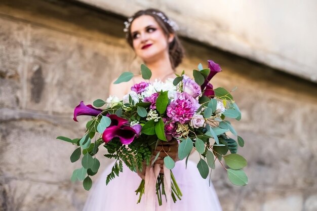 Foto buquê de casamento nas mãos da noiva fecha flores de lírios vermelhos vívidos