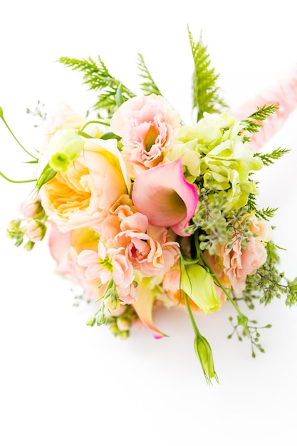 Buquê de casamento pequeno com rosas em um fundo branco.