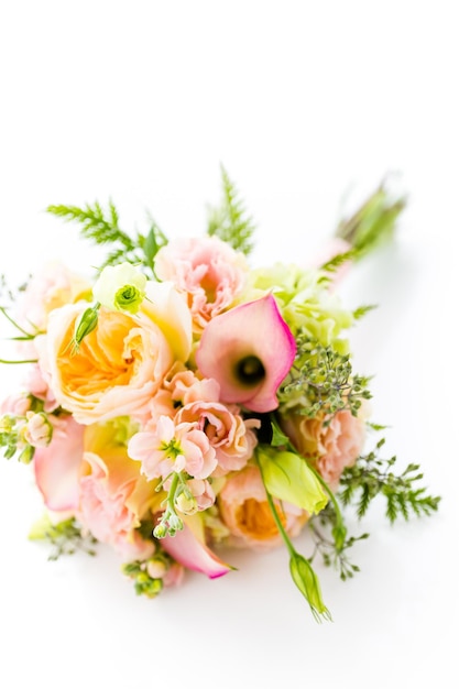 Buquê de casamento pequeno com rosas em um fundo branco.