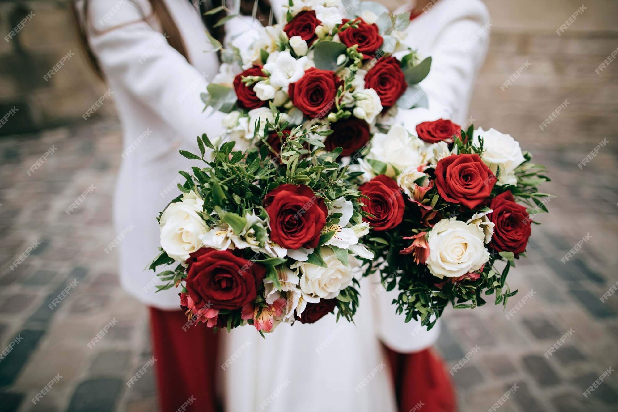 Buquê de casamento vermelho nas mãos da noiva | Foto Premium