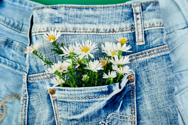 Buquê de flor branca no bolso de uma calça jeans