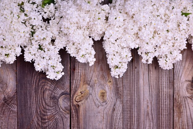 Buquê de flores brancas lilases em uma superfície de madeira cinza