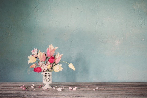 Buquê de flores da primavera na parede azul antiga