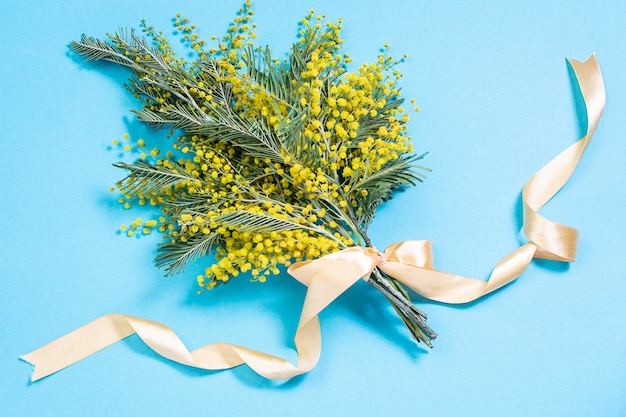 Buquê de flores de mimosa em fundo azul claro. Bela composição de primavera