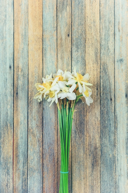 Buquê de flores de narcisos em closeup grunge retrô de madeira