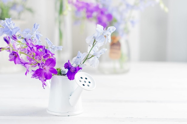 Buquê de flores de tremoço roxo em um entalhe na mesa de madeira branca