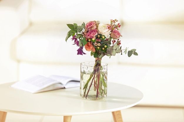 Buquê de flores em jarra em cima da mesa