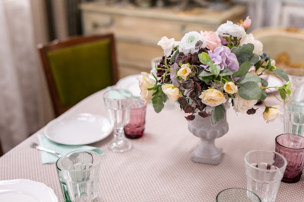 Buquê de flores em um vaso na mesa de casamento.