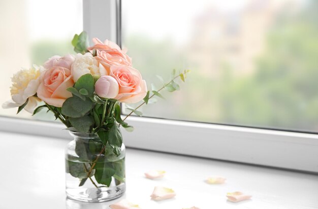Buquê de flores em um vaso no peitoril da janela
