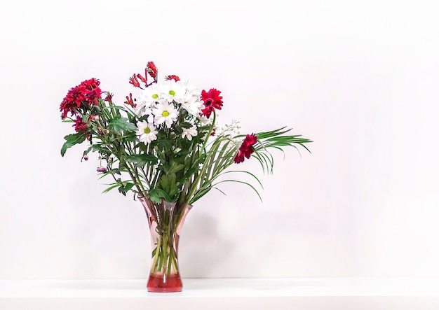 Buquê de flores em vaso de vidro no fundo branco