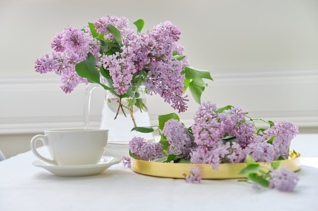 Buquê de flores lilás em jarra de vidro na mesa