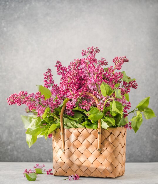 Buquê de flores lilases coloridas em uma cesta de vime