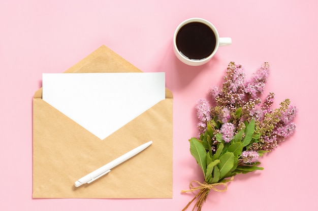 Buquê de flores rosa, envelope com cartão em branco branco