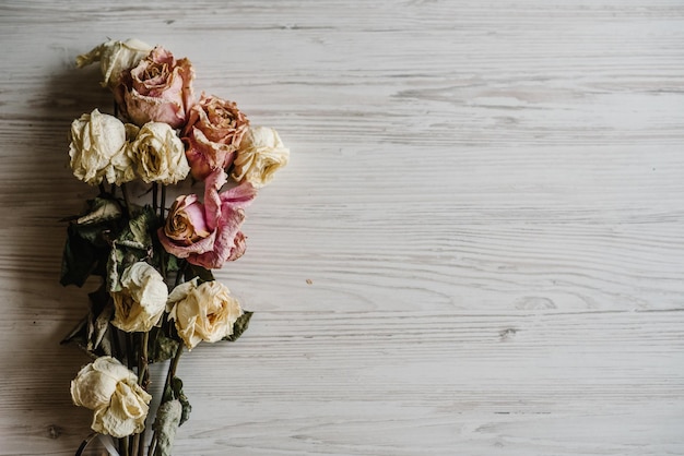 Buquê de flores secas composição de flores feita de rosa seca em fundo branco de madeira espaço de cópia de vista superior plana leiga lugar para texto e design