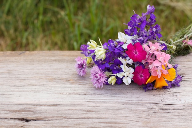 Buquê de flores silvestres na velha tábua de madeira