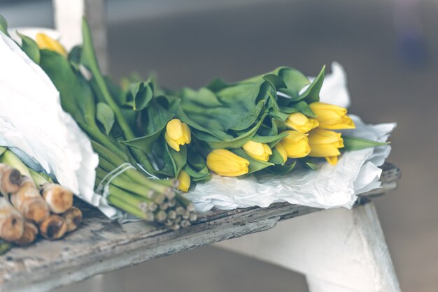 Buquê de flores tulipas amarelas sobre uma mesa de madeira