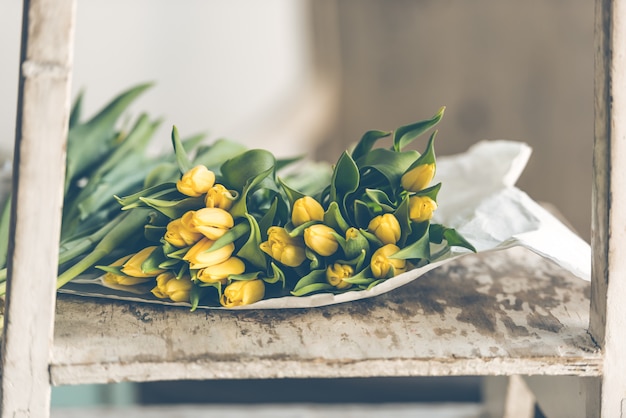 Buquê de flores tulipas amarelas sobre uma mesa de madeira