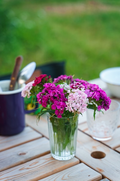 Foto buquê de flox em uma mesa de jardim servido para uma refeição familiar ao ar livre