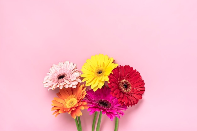 Foto buquê de gérberas em fundo rosa vista superior flat lay cartão de felicitações de férias feliz dia do moter