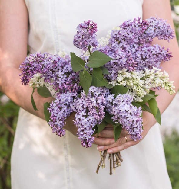 Buquê de lilases nas mãos femininas