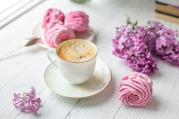 Buquê de lilases, xícara de café, marshmallow caseiro. manhã de primavera romântica