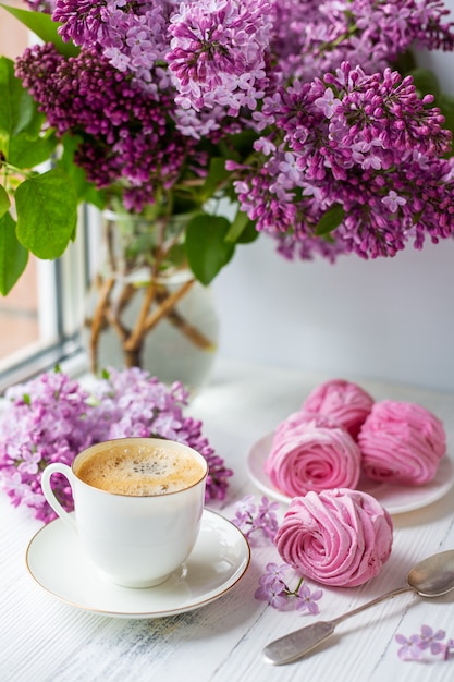 Buquê de lilases, xícara de café, marshmallow caseiro. Manhã de primavera romântica