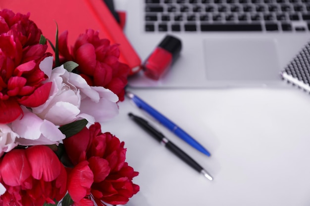 Buquê de lindas flores de peônia no local de trabalho desfocado como plano de fundo