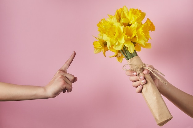 Buquê de narcisos amarelos em um fundo rosa