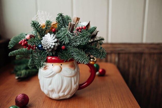 Buquê de Natal de Inverno em uma tigela engraçada na mesa perto da janela