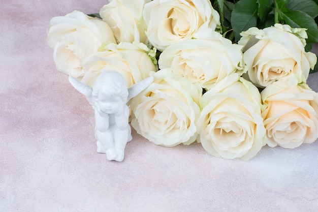 buquê de rosas brancas closeup e estatueta de anjo branco