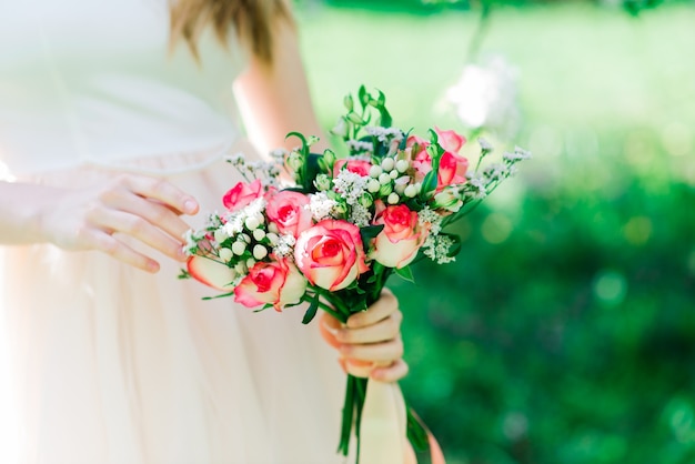 Buquê de rosas brancas e vermelhas nas mãos da noiva