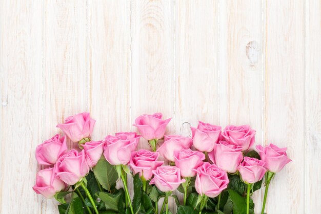 Buquê de rosas cor de rosa sobre a mesa de madeira