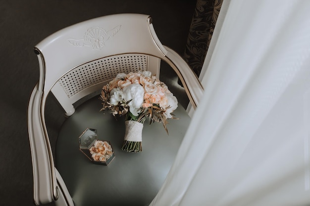 buquê de rosas de casamento e várias flores em uma cadeira na sala de casamento