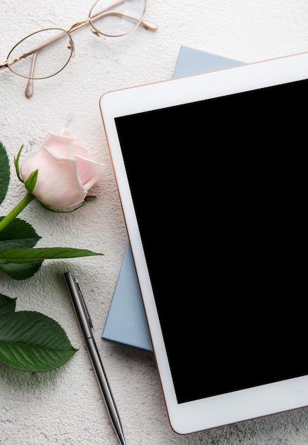 Buquê de rosas e tablet em fundo de concreto