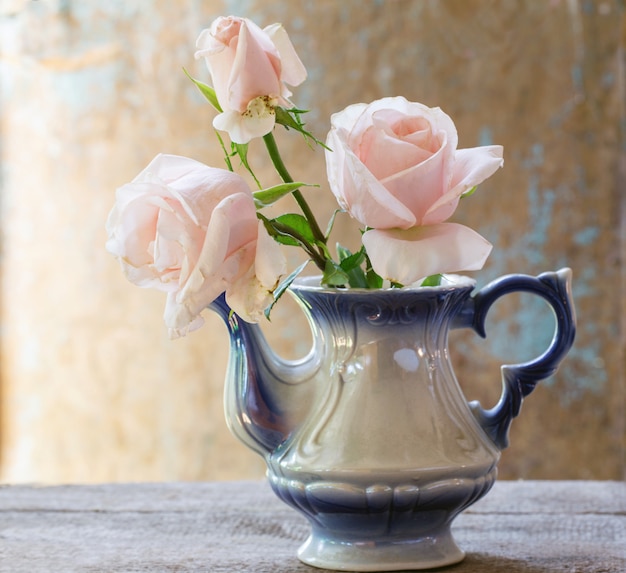Foto buquê de rosas em um bule de chá vintage em estilo rústico