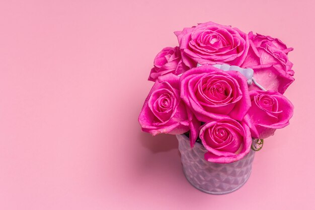 Foto buquê de rosas frescas em um balde. o conceito festivo para casamentos, aniversários, dia 8 de março, dia das mães ou dos namorados. cartão de felicitações, fundo rosa claro