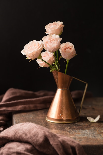 Buquê de rosas no jarro de cobre antigo