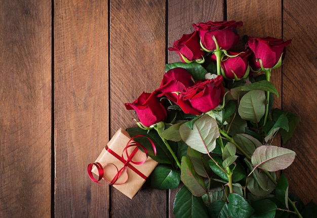 Buquê de rosas vermelhas em uma mesa de madeira.