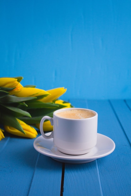 Buquê de tulipas amarelas e uma xícara de café