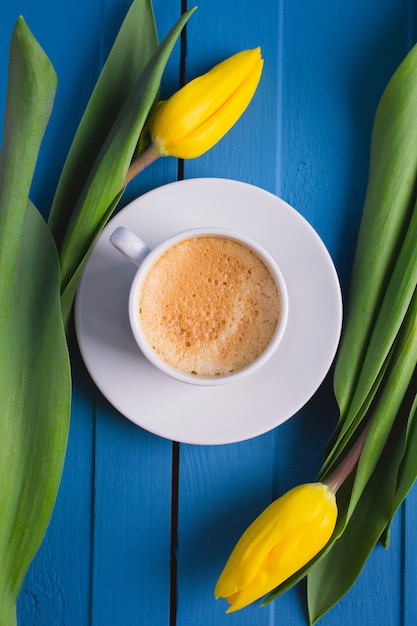 Buquê de tulipas amarelas e uma xícara de café