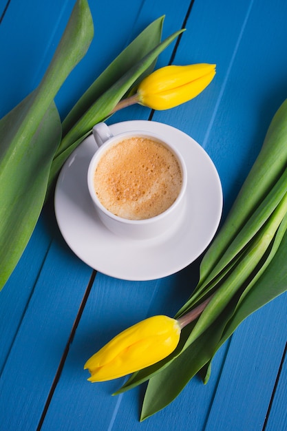 Buquê de tulipas amarelas e uma xícara de café