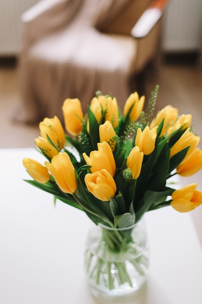 buquê de tulipas amarelas frescas em uma mesa no interior da sala de estar