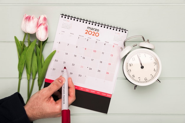 Foto buquê de tulipas ao lado do relógio e calendário