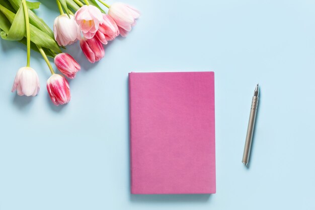 Buquê de tulipas cor de rosa e vazio em branco para felicidades em azul.